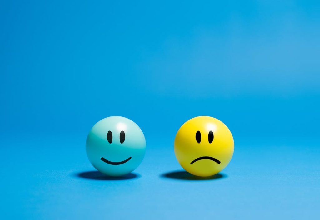 contrasting-emotions-on-smiley-balls-29205873 Two smiley balls representing opposite emotions on a blue background.